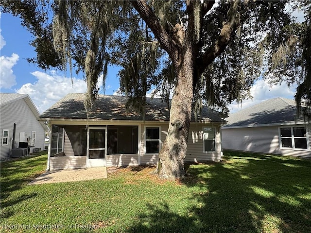 back of property with a sunroom and a lawn