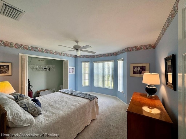 carpeted bedroom with a ceiling fan, a closet, visible vents, and baseboards