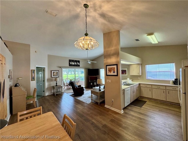 kitchen with dark wood-style flooring, light countertops, hanging light fixtures, open floor plan, and white appliances