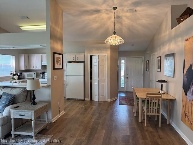 kitchen featuring white appliances, plenty of natural light, visible vents, and dark wood finished floors