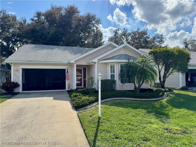 ranch-style home with a garage, a front yard, concrete driveway, and a shingled roof