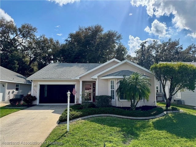 single story home with a garage, driveway, a shingled roof, and a front lawn