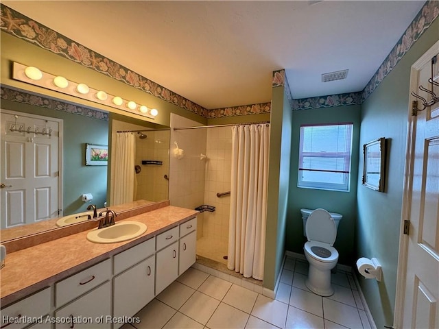 full bathroom with tiled shower, vanity, toilet, and tile patterned floors