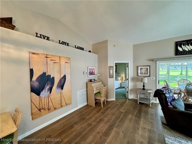 interior space featuring lofted ceiling, visible vents, baseboards, and wood finished floors