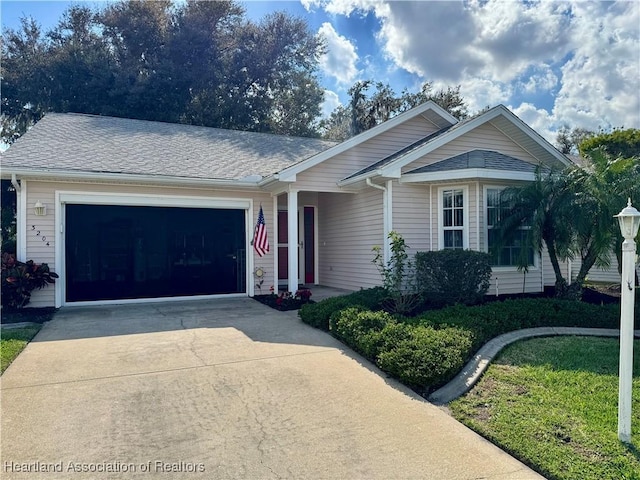 single story home featuring a garage, concrete driveway, and a shingled roof