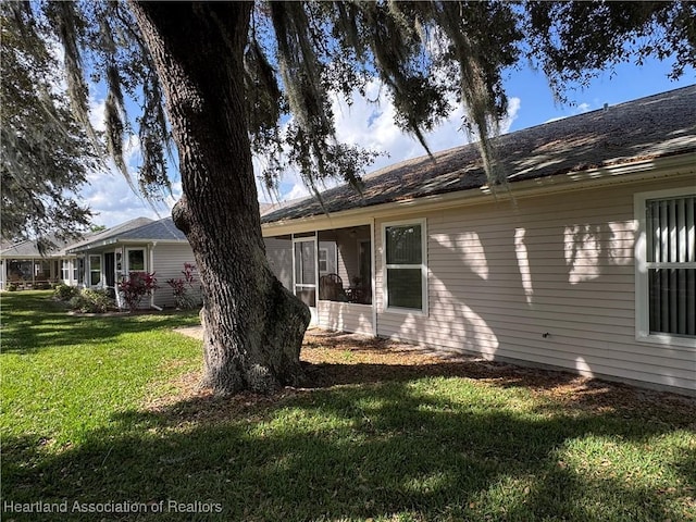 view of property exterior with a yard and a sunroom