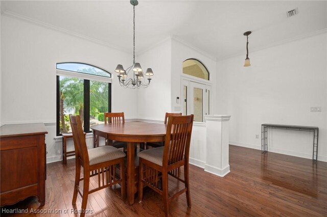 dining space with visible vents, crown molding, baseboards, a notable chandelier, and dark wood-type flooring