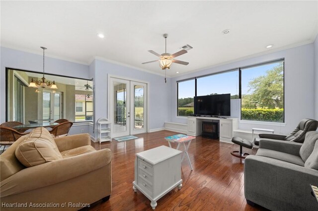 living room featuring visible vents, ornamental molding, dark wood-style floors, recessed lighting, and ceiling fan with notable chandelier