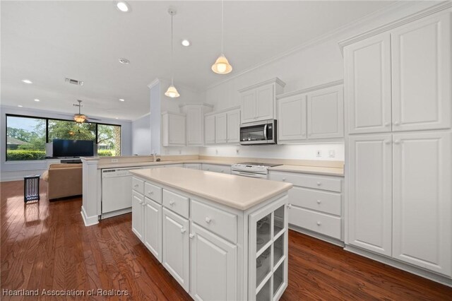 kitchen featuring white appliances, white cabinetry, dark wood-type flooring, and a center island