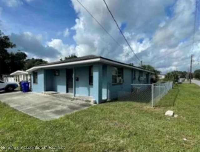 exterior space featuring a lawn and fence