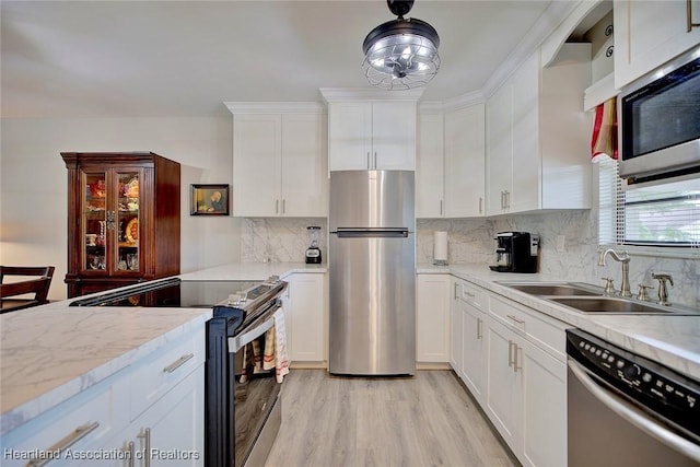 kitchen with decorative backsplash, white cabinetry, sink, and stainless steel appliances