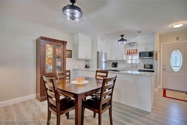 dining room with sink and light wood-type flooring