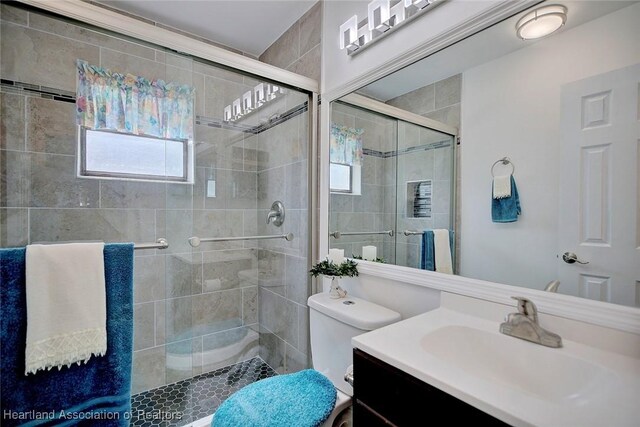 bathroom featuring vanity, toilet, and an enclosed shower