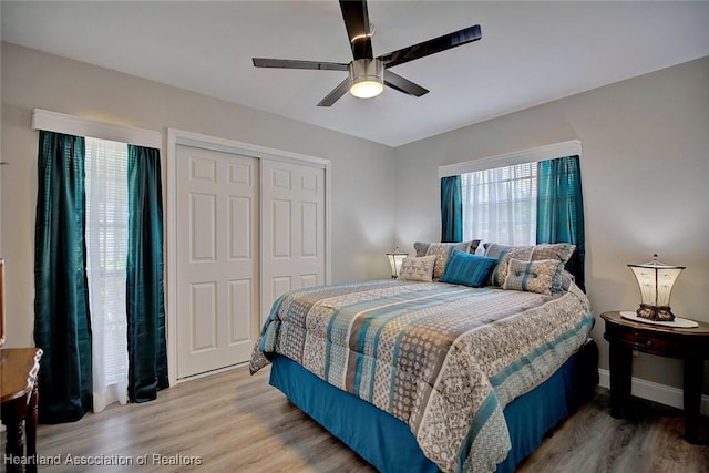 bedroom featuring hardwood / wood-style flooring, ceiling fan, and a closet