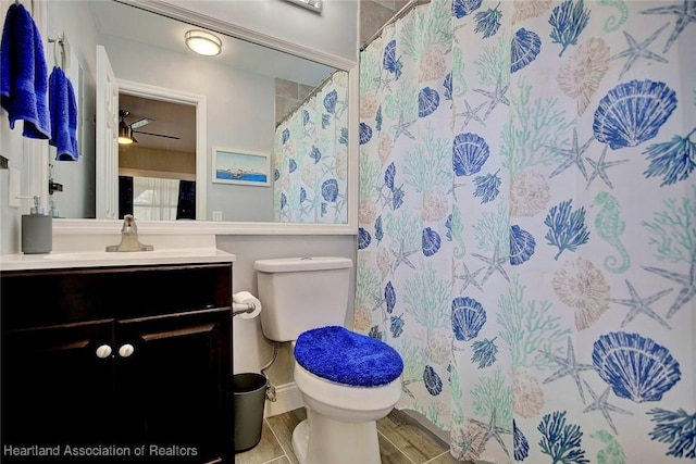 bathroom with a shower with curtain, ceiling fan, vanity, and toilet