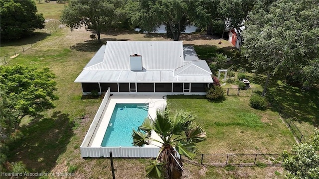 view of pool with a lawn, a fenced in pool, a fenced backyard, and a sunroom