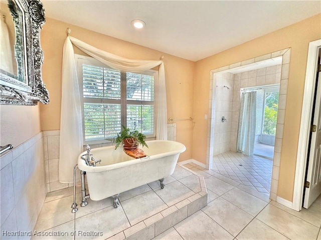 bathroom featuring a freestanding tub, tile patterned flooring, and tiled shower