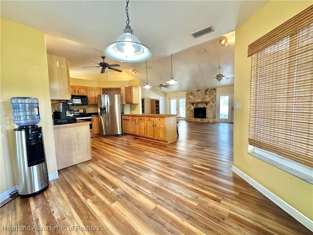 kitchen featuring ceiling fan, visible vents, a peninsula, open floor plan, and stainless steel appliances