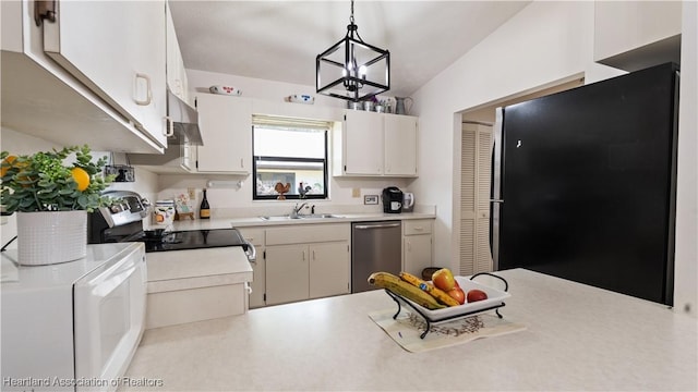 kitchen featuring black refrigerator, sink, hanging light fixtures, stainless steel dishwasher, and a chandelier