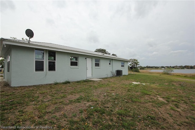 back of property featuring central AC and a yard