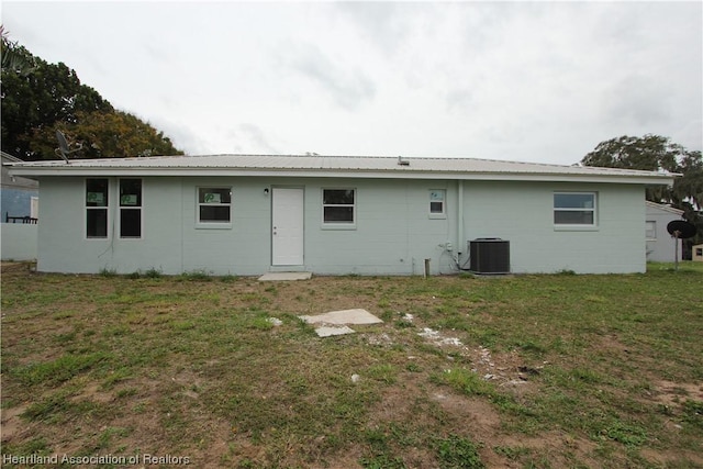 rear view of house featuring a lawn and central AC