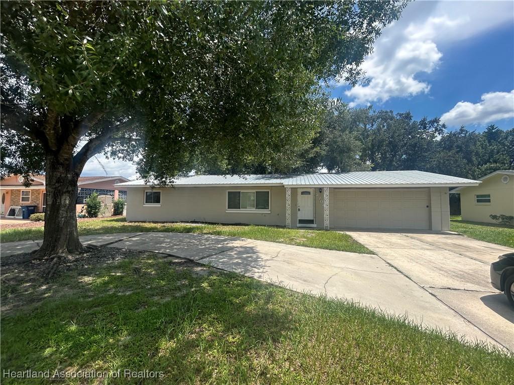 ranch-style home with a garage and a front lawn