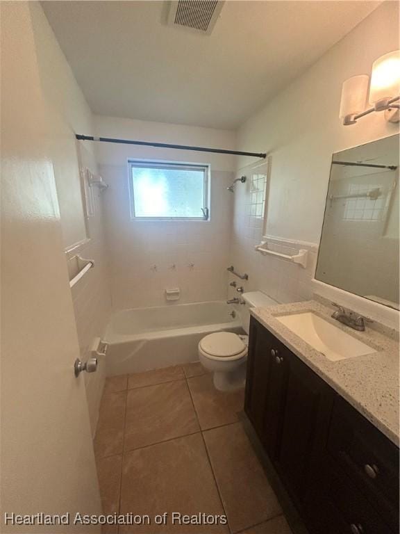 full bathroom with toilet, vanity, tile patterned floors, and tiled shower / bath combo