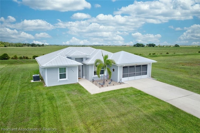 ranch-style house featuring central AC unit, a rural view, a front yard, and a garage