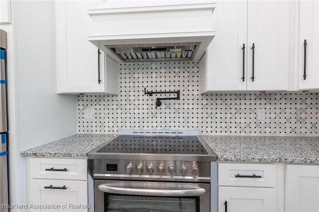 kitchen featuring white cabinetry, tasteful backsplash, light stone countertops, and stainless steel range with electric cooktop