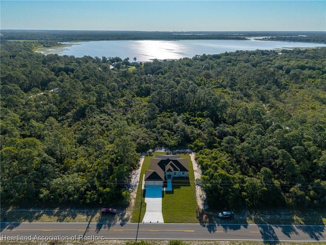 aerial view featuring a wooded view and a water view