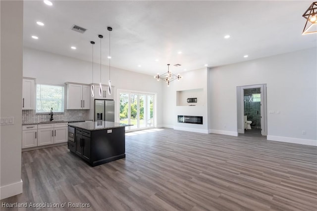 kitchen with recessed lighting, stainless steel fridge with ice dispenser, a center island, a sink, and visible vents