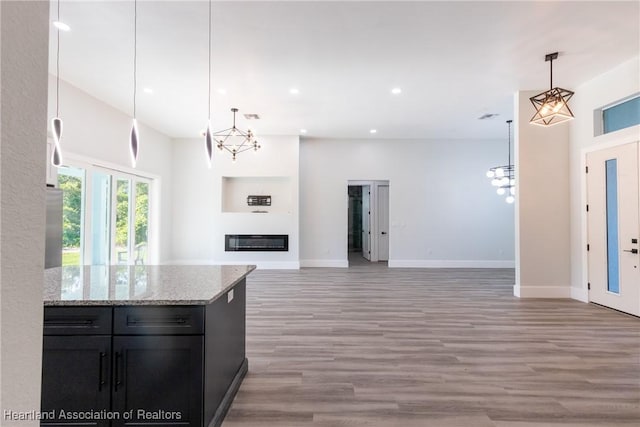 kitchen featuring baseboards, an inviting chandelier, and light wood-style flooring