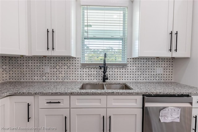 kitchen with a sink, dishwasher, white cabinetry, and tasteful backsplash