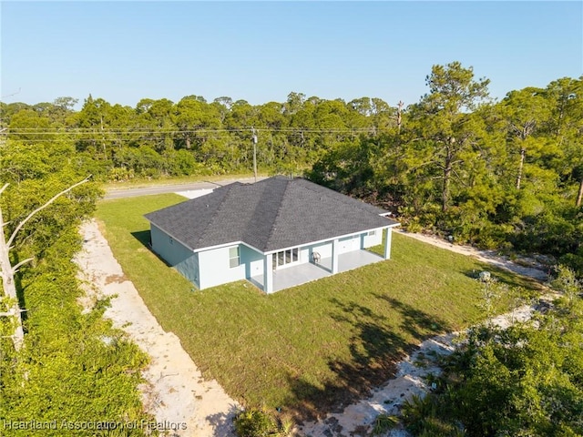 bird's eye view with a wooded view