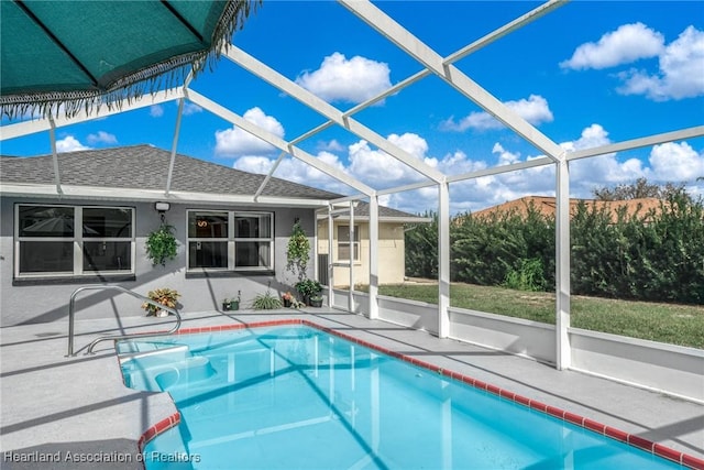 view of swimming pool with glass enclosure and a patio