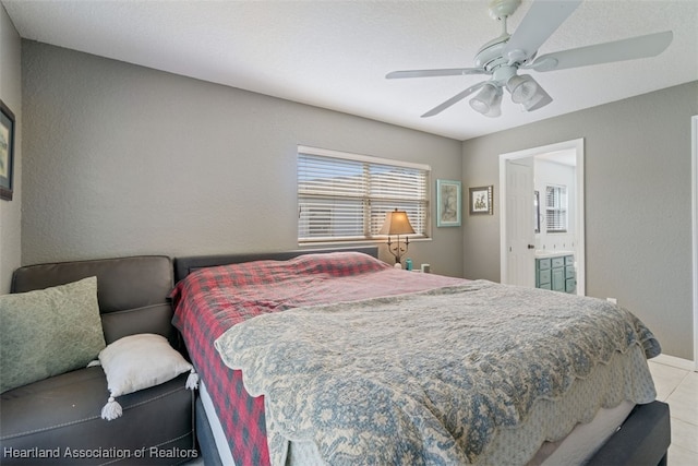 bedroom with light tile patterned floors, ensuite bath, and ceiling fan