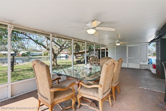 sunroom featuring a water view