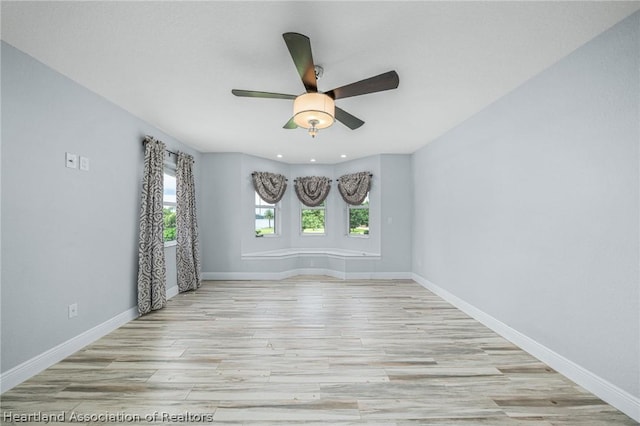 unfurnished room with ceiling fan and light wood-type flooring