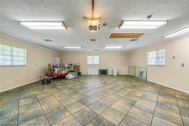 empty room featuring ornamental molding, a textured ceiling, and a healthy amount of sunlight