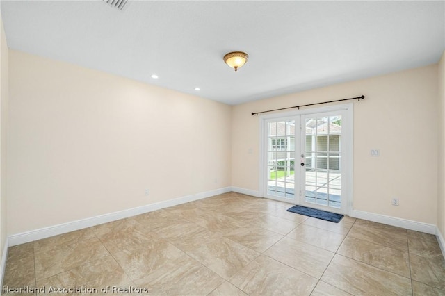 empty room featuring light tile patterned flooring and french doors