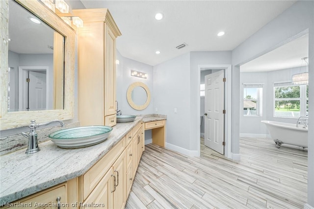 bathroom featuring vanity and a bath