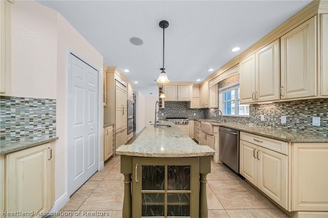 kitchen featuring light stone counters, stainless steel dishwasher, pendant lighting, a center island with sink, and light tile patterned floors