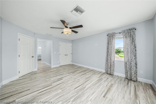 empty room with ceiling fan and light hardwood / wood-style floors