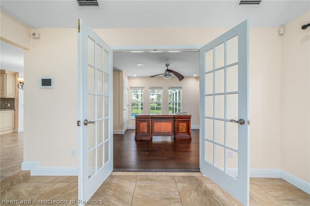 hallway featuring light tile patterned floors and french doors