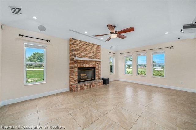 unfurnished living room with a fireplace, light tile patterned floors, and ceiling fan