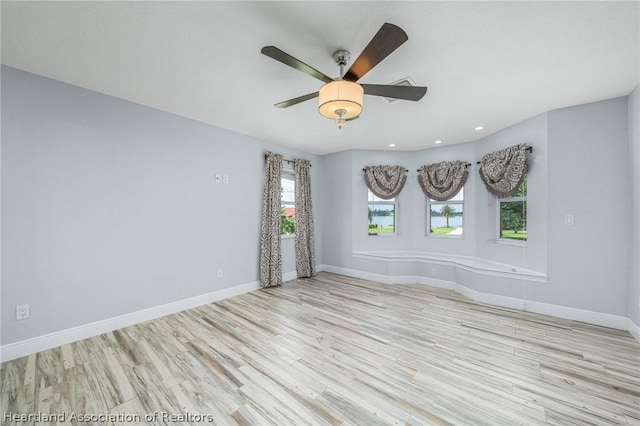 spare room with ceiling fan and light wood-type flooring