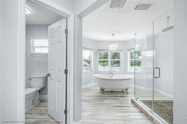 bathroom featuring separate shower and tub, plenty of natural light, and toilet