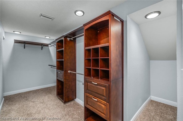 spacious closet featuring light carpet