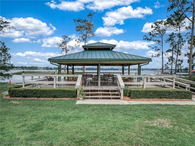 dock area featuring a gazebo, a water view, and a lawn