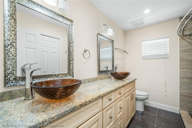 bathroom featuring tile patterned flooring, vanity, and toilet